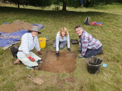 volunteers around a test pit